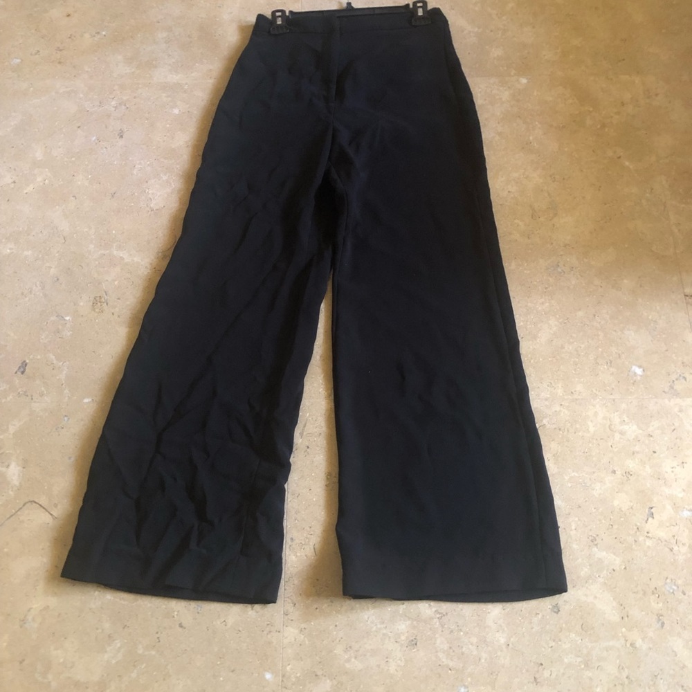 Woman black pants, wide legs, high waist, very stylish.